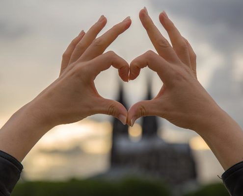 Hände formen ein Herz vor Kölner Dom
